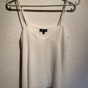 Vitt linne från topshop  - Vitt linne i tunt material. Normal i storlek i fint skick. 