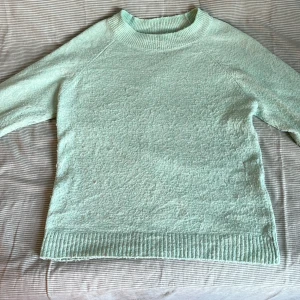 Mintgrön stickad tröja Vero Moda XS - Superfin mintgrön stickad tröja från Vero Moda i storlek XS. Tröjan har rund halsringning, ribbade muddar och är långärmad. Perfekt för lager-på-lager och ger en fräsch vibe till din outfit.