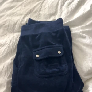 Mörkblå mjukisbyxor Juicy Couture M - Mörkblå mjukisbyxor från Juicy Couture med snörning i midjan och fickor på rumpan 
