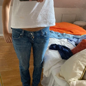 Levis  low waist blå jeans bootcut - Säljer ett par klassiska Levis jeans i blå tvätt med låg midja och bootcut. Jeansen har fem fickor och den ikoniska Levis-detaljer på bakfickorna. Perfekta för dig som gillar en avslappnad och tidlös look. Skriv för mått🩷