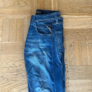 Blå Replay Anbass jeans - Väldigt bra skick, lite skrynkliga och en liten defekt på sista bilden som ej syns vid användning. Storleken är 28/30 