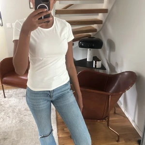 Vit basic t-shirt  - Enkel och stilren vit t-shirt från SHEIN med rund halsringning och korta ärmar. Perfekt att matcha med jeans eller kjol för en clean look. T-shirten har en klassisk passform och är gjord i mjukt material som känns skönt mot huden.