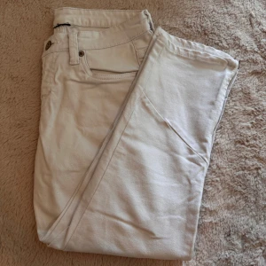 Vita trekvartsbyxor med dragkedja vid benslut - Snygga vita trekvartsbyxor och dragkedja vid bensluten för en cool detalj. Byxorna har normal passform och är perfekta för dig som vill ha en clean och stilren look.