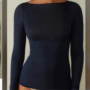 Mörkblå intimissimi tröja  - Snygg mörkblå långärmad topp med tight passform och rund halsringning. Enkel och stilren design som passar perfekt till jeans eller kjol. Mjuk och stretchig känsla, perfekt för lager-på-lager eller som den är. Knappt använd ifrån intimissimi
