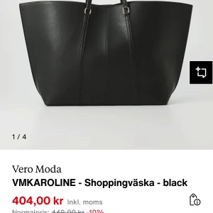 Svart shoppingväska från Vero Moda - Stilren svart shoppingväska från Vero Moda med minimalistisk design och rymligt huvudfack. Väskan har två smala axelband och är tillverkad i syntetmaterial med en lätt glansig finish. Perfekt för dig som vill ha plats för allt du behöver under dagen.