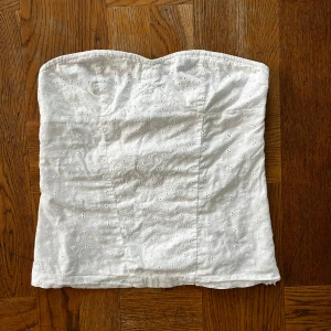 Vit broderad tubtopp i bomull - Supersöt vit tubtopp i bomull med broderade små blommor och hålmönster