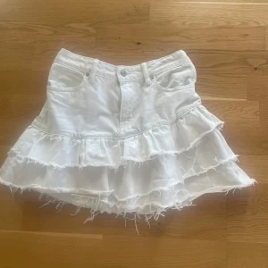 Vit volangkjol från Gina Tricot - Supersöt vit jeanskjol från Gina Tricot med flera volanger. Perfekt för dig som vill ha en trendig och lekfull look i sommar. Priset går att diskutera!!