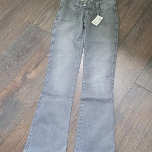 Grå bootcut jeans Paris Patch XS - Grå jeans från lager 157 i modellen Paris patch storlek XS full. De är helt nya och aldrig använda eller provade då jag råkade köpa i fel storlek. Prislappen är kvar. Original pris 400 jag säljer för 100. Tryck inte på köp om vi inte är överens!