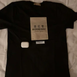 Svart Burberry t-shirt med logga - Köp burberry tröja med shorts så ni får den perfekta seten för sommaren. Tröjan är stl S och shorten är Stl m.OM NI VILL BARA KÖPA TRÖJAN SKRIV DET TILL MIG SÅ LÖSER VI ETT PRIS. Pris kan diskuteras.Svart t-shirt från Burberry i storlek S med stor beige logga och tryck på bröstet. Klassisk passform och rund halsringning. Perfekt för dig som gillar stilrena designer och vill sticka ut med ett exklusivt märke.