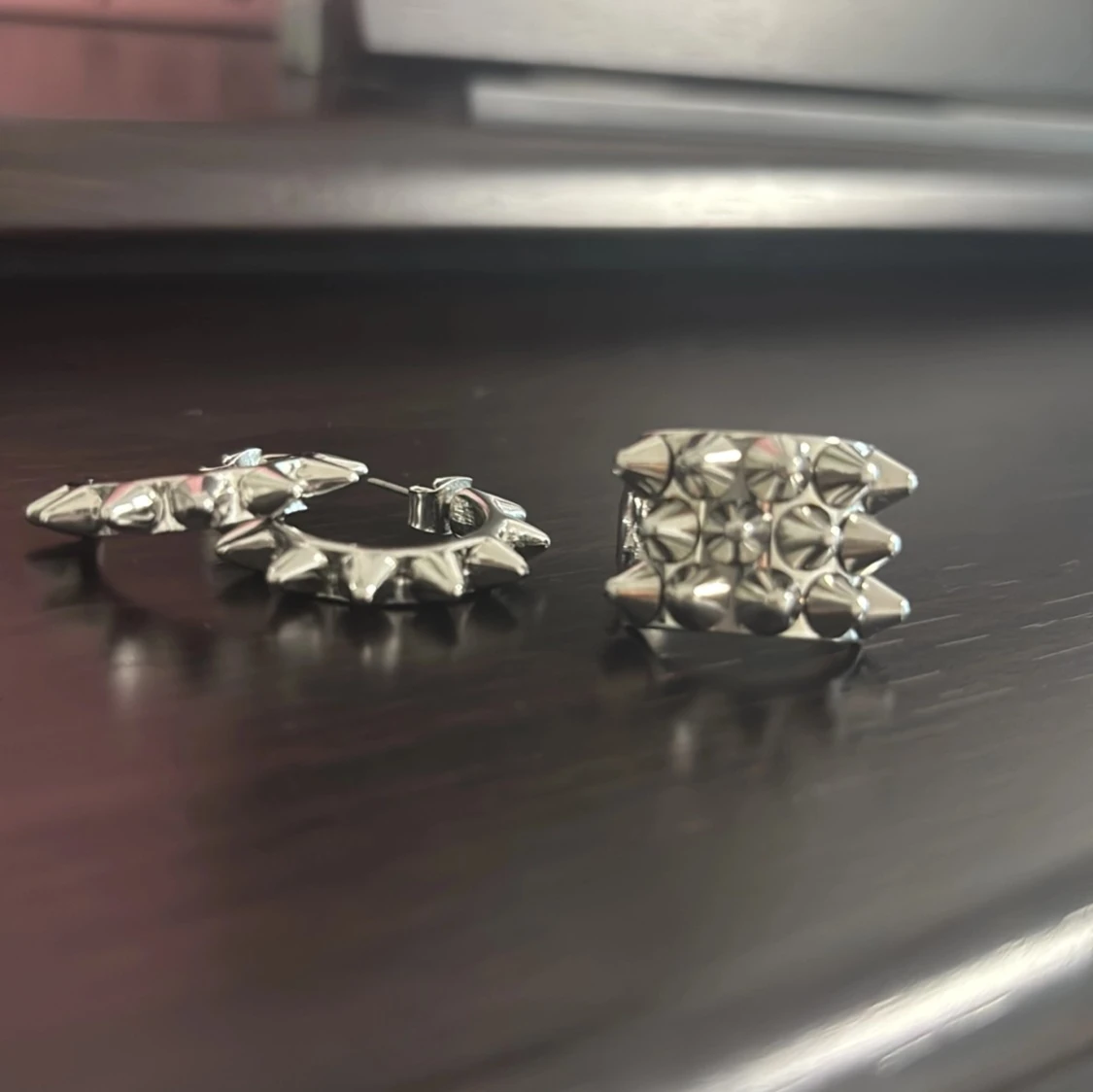 Silvriga örhängen och ring med nitar