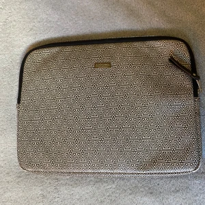 Svartvit datorväska med grafiskt mönster - Snygg datorväska  i svartvitt grafiskt triangulärt mönster. Väskan har dragkedja upptill och är vadderad på insidan för extra skydd. Perfekt för att bära din laptop till plugget eller jobbet.