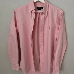 Rosa Ralph Lauren Skjorta - Slim fit - S - Skön Ralph lauren skjorta i storlek S i den sjukt eftertraktade modellen Slim fit. Skjortan har inga defekter överhuvudtaget och är i 10/10 skick - så gott som ny. Säljer då den inte passar och pris kan diskuteras vid snabb affär. Vid frågor eller funderingar hör gärna av dig :)