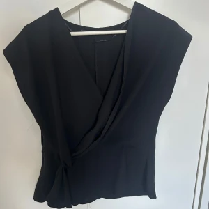 Svart Zara Blus - Svart blus från Zara som gått upp lite i sidan men det är ej synligt när man bär den. Säljer för att den inte kommer till användning. Pris kan diskuteras.