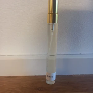 Minya parfym från Paris Corner 10 ml split  - Minya från Paris Corner är en lyxig parfym med doftnoter av mandel, pistage, heliotrop, jasmin, vanilj, salt karamell och sandelträ. Flaskan är elegant med guldigt lock och transparent glas. Doften är söt, nötig, blommig och träig med inslag av vanilj och karamell.