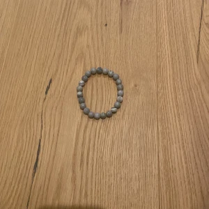  Pärlarmband  - Säljer fyra elastiska armband med runda pärlor. Ett armband är gråmelerat, ett är svart, ett är vitt med grå marmorering och ett är helvitt. Perfekta att mixa och matcha för en stilren look. Passar både tjejer och killar som gillar enkla accessoarer, de är även tillverkade i frankrike.