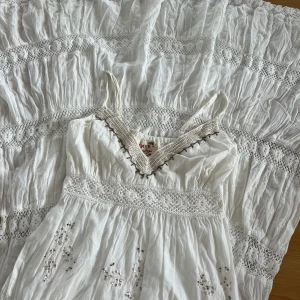 Långklänning  - Superfin vit långklänning från Falmer Heritage med broderade detaljer, spetsinslag och pärlor längs v-ringningen🌸xs/s     (finns några gula nyanser nertill klänningen)