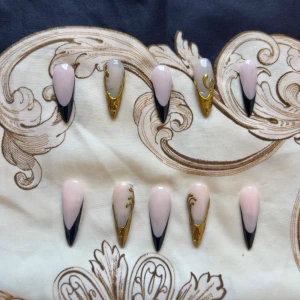 Handgjorda Press-on naglar svart och guld  - Snygga press-on naglar i stilett/mandelform som jag gjort själv. De kan användas många gånger och göras i flera olika storlekar. Kan även göra custom designs om så önskas!🖤⚜️