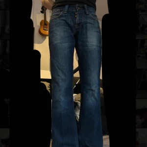 Blå bootcut jeans från Jack & Jones - Snygga blå jeans från Jack & Jones med bootcut passform. Jeansen är försmå för både mig och min sambo (som modellar på bilderna) därav fick han inte igen alla knappar i gylfen men annars har de en väldigt bra passform och är skitsnygga🌺