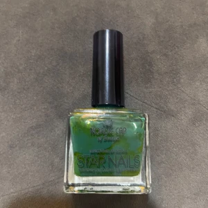 Grönt nagellack Nordic Cap Star Nails - Grönt nagellack från Nordic Cap Star Nails med fyrkantig glasflaska och svart lock. Färgen är intensivt grön och passar perfekt för dig som vill sticka ut med dina naglar. Lätt att applicera med klassisk borste.