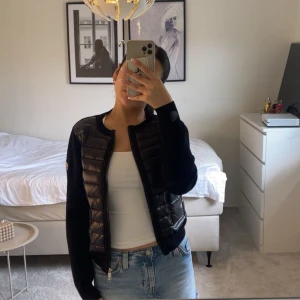 Svart cardigan jacka från Moncler - Säljer en svart cardigan jacka från Moncler med quiltad framsida och två fickor. Jackan har långärmade stickade ärmar och dragkedja framtill. Perfekt för dig som gillar en clean och stilren look. Helt ny, använd väldigt få tal gånger. Ingen äktehetsbevis, därav pris!!! Fråga gärna om fler bilder!!💕💕