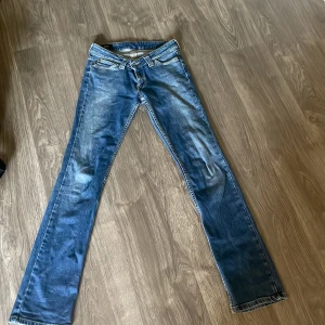 Blå Lee Maddox jeans bootcut 26/33 - Snygga blå jeans från Lee, modell Maddox, med klassisk bootcut och normal passform. Jeansen har fem fickor, Lee-lapp bak och är tillverkade i bomull med lite stretch. Midjemått ungefär 83cm. Innerbenslängd ungefär 85 cm. Slutar 2cm över marken för mig som är 175-176cm. 