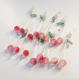 Söta körsbärsörhängen med pärlor - Supergulliga örhängen med körsbärsdesign! De har rosa och röda pärlor som bär, gröna blad i glas och vita pärldetaljer. Hängande modell med silverfärgade stänger. Perfekta för dig som vill ha något lekfullt och unikt i öronen.