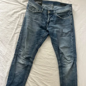 Dondup George jeans - Blåa dondup jeans med en skön tvätt. Dem är modellen George vilket har en slim passform. De är i storlek 32 och är i ett fint skick utan stora täcken på andvänding. Skriv för det minsta lilla/ Karl