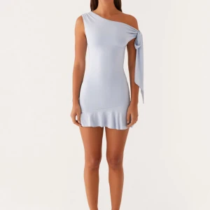 Palm House Mini Dress - Blue - Superfin ljusblå kortklänning från Peppermayo med one shoulder och stor knytrosett på axeln. Klänningen har en tight passform och volangkant nertill som ger en söt touch. Perfekt nu till sommaren!!💕💕endast testad med prislapp kvar⭐️