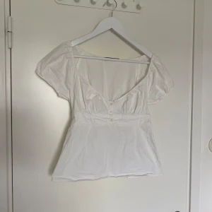 Vit topp från Brandy Melvillle - Säljer min vita topp från Brandy Melville då den är lite stor för mig! Den är i mycket fint skick, endast lite skrynklig. Om du har några frågor är det bara att skriva!☺️🤍