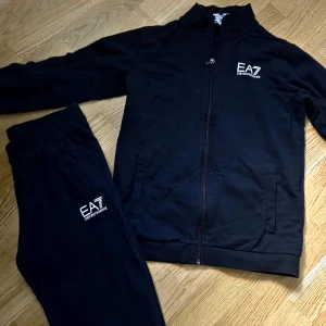 Svarta mjukisbyxor från EA7 Emporio Armani - Svarta mjukisbyxor från EA7 Emporio Armani  och en zip tröja I lika..stl 158/160,,,,,djur och rökfritt,,,finns i centrala gävle,, 300kr för båda,hela seytet