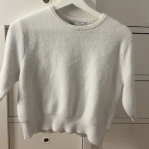 Vit stickad tröja från Zara - Mysig vit stickad tröja från Zara med rund halsringning och ribbade muddar. Tröjan har en enkel och stilren design som passar perfekt till många olika outfits. Storlek Medium men skulle säga small då den är lite kroppad❤️