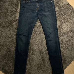 Mörkblå jeans från Jacob Cohën - Snygga mörkblå jeans från Jacob Cohën med klassisk femficksdesign och guldfärgade detaljer. Byxorna har normal passform och raka ben, samt en patch i mocka baktill i midjan. Perfekta för dig som gillar stilrena jeans med exklusiv känsla.