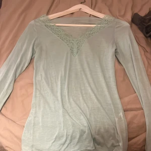 Ljusgrön långärmad topp med spets från Intimissimi - Säljer en jätte fin turkos/ljusgrön långärmad topp från Intimissimi med v-ringning. använd 2 gånger, säljer pga används inte 😇💕
