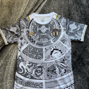 Italien fotbollströja specialdesign - Unik vit och svart Italien fotbollströja från Adidas med detaljerat grafiskt mönster och guldiga inslag på axlar och logga. Kortärmad modell med rund hals och broderad landslagssköld på bröstet.