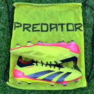 Adidas Predator  - Säljer ett par Adidas Predator fotbollsskor i neon-gult med svarta och röda detaljer. Skorna har snörning och är designade för spel på gräs. Ikoniska svarta ränder på sidorna och Predator-logga. Perfekta för dig som vill sticka ut på planen. (Skick 8/10)