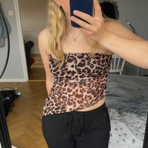 Leopard tubtopp - Snygg leopardmönstrad tubtopp. Toppen är i mesh likande material. Notera att den svarta förstärkningen framtill inte är så bred