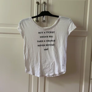 Vit t-shirt från Abercrombie & Fitch - Vit t-shirt från Abercrombie & Fitch med svart texttryck framtill. Rund halsringning och korta ärmar. I super skönt bomull, strl S