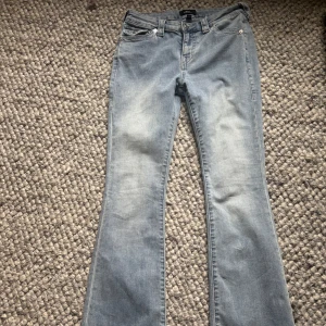 Ljusblå bootcut jeans från True Religion - Säljer ett par ljusblå jeans från True Religion, modell BECCA Mid Rise Bootcut. Jeansen har en väldigt skön passform, dock är de ihop sydda bak under en ficka men inget som man tänker på när man har på sig jeansen. På sista bilden ser du hur de är ihopsydda!💞