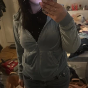 Ljusblå velour hoodie från Female Passion - Mysig ljusblå hoodie i velour från Female Passion. Jackan har dragkedja framtill, huva och två stora fickor. Perfekt för en avslappnad stil och enkel att matcha med jeans eller mjukisbyxor.
