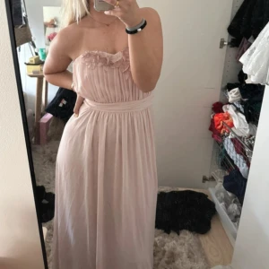 Ljusrosa axelbandslös balklänning med blommiga detaljer - Säljer denna fina balklänning från HM , hittade en som jag hellre ville ha. Fint skick.