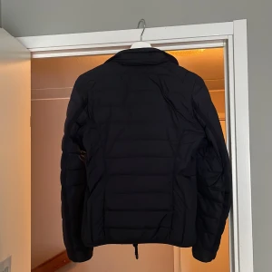 Svart superlätt dunjacka från Parajumpers - Säljer en svart superlätt dunjacka från Parajumpers i storlek XS. Jackan har quiltad design, dragkedja framtill och två fickor med dragkedja. Insidan är ljusbeige och jackan är perfekt för kyliga dagar. Priset kan diskuteras 