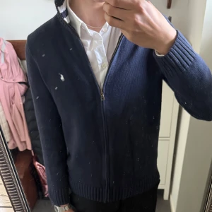 Svart stickad kofta från Polo Ralph Lauren - Svart stickad kofta med dragkedja från Polo Ralph Lauren. Tröjan har ribbade muddar, vit broderad logga på bröstet och en krage med vita ränder. Perfekt till lager-på-lager och klassisk stil. Size S tts. Fint skick! För frågor kom pm / Neo💫