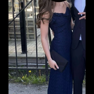 Marinblå långklänning med smala axelband - Säljer min underbara balklänning, endast använt den en gång och har sytt upp banden på den för att den sitter bättre, det är stretchigt material och passar många. Den är slutsålt så passa på!!