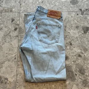 Ljusblå Levis 501 jeans - Säljer ett par klassiska ljusblå Levis 501 jeans. Storlek W32, L36. Väldigt snygga jeans enligt mig och är i bra skick. Nypriset ligger på cirka 1400 så ett väldigt bra pris.