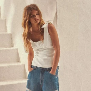 Popoluär Zara topp - Snygg vit linnetopp med breda axelband och en dekorativ rosett på ena axeln. Aldrig använd!