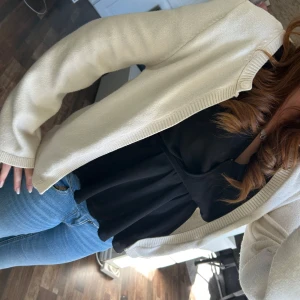 Beige kofta från Gina Tricot - Snygg beige kofta från Gina Tricot med rund hals och ribbade kanter. Långärmad och i mjukt stickat material som är perfekt att slänga över en topp eller t-shirt. Enkel och clean design som funkar till jeans eller kjol. Passar dig som gillar stilrena plagg.