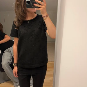 Svart stjärnmönstrad topp Maison Scotch - Cool, festlig svart topp från Scotch & Soda med glittriga stjärnor över hela plagget. T-shirtdesign med kort ärm och rund halsringning. Materialet är lite strukturerat och ger en lyxig känsla. Passar mig som är S/M💕