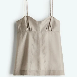 Beige linnetopp med smala axelband - Snygg beige linnetopp med smala axelband och lätt rynkade detaljer vid bysten. Toppen är helt ny med prislapp kvar säljer för jag glömde att skicka tillbaka dem 