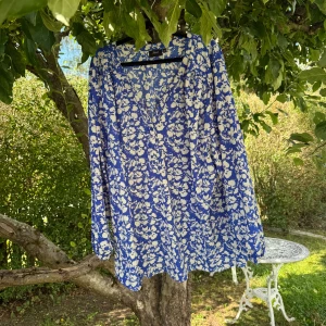 Blå blus med vita detaljer  - Supersöt blus från Zizzi med blå botten och små blommor i vitt. Blusen har v-ringning, långa ärmar med resår vid ärmslut och ett flowigt fall. Perfekt för dig som gillar färg och mönster! Storlek XXL. Mycket fint skick, jag hittar inga synliga anmärkningar eller defekter.