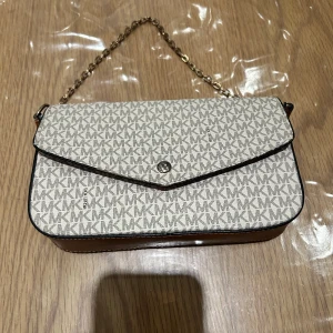 michael Kors axelväska med kedja - Snygg axelväska från michael kors. Den är knappt anväbd och är billig. Hjälper en vän med att sälja den. Pris kan diskuteras 